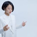 Tablette transparente futuriste manipulée dans un univers minimaliste et technologique au design épuré.
